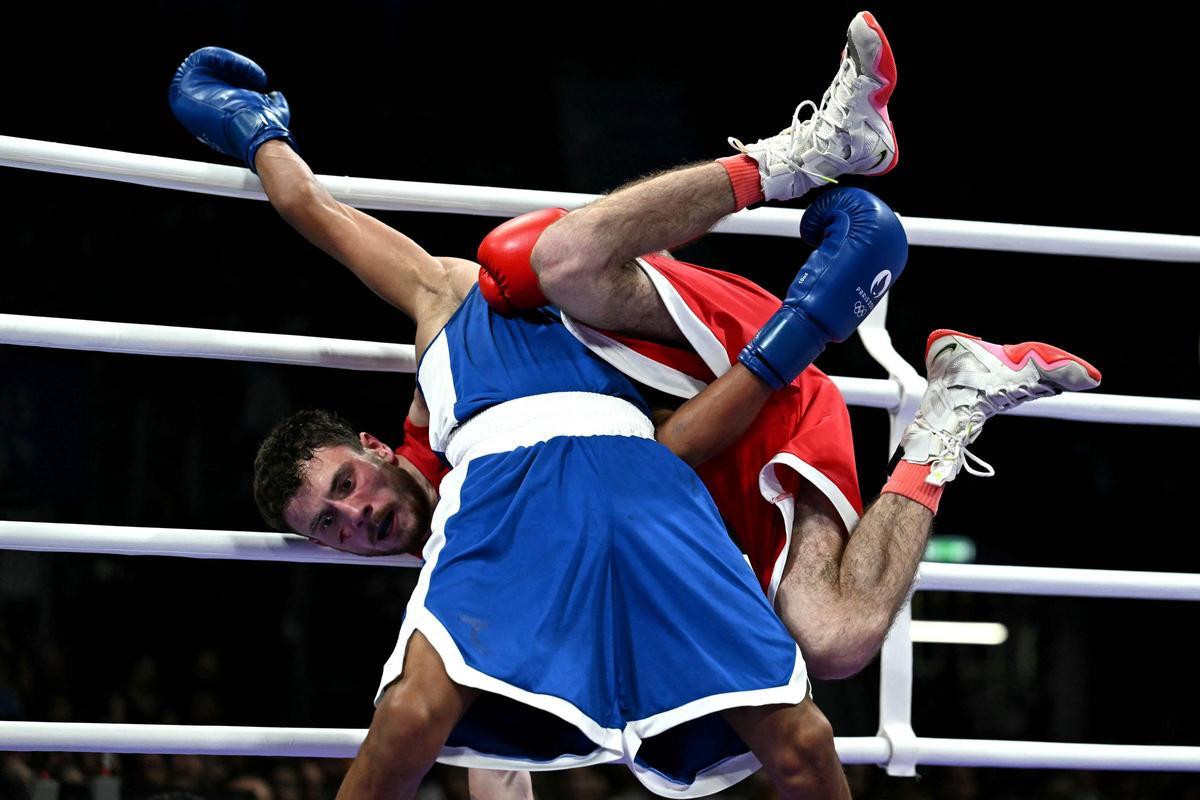 Yunior Alcantara Reyes (de azul) de la República Dominicana pelea contra Nijat Huseynov de Azerbaiyán en la ronda de 1/8 de final de la competición de boxeo, categoría de 51 kg, durante los Juegos Olímpicos de París 2024 en el North Paris Arena