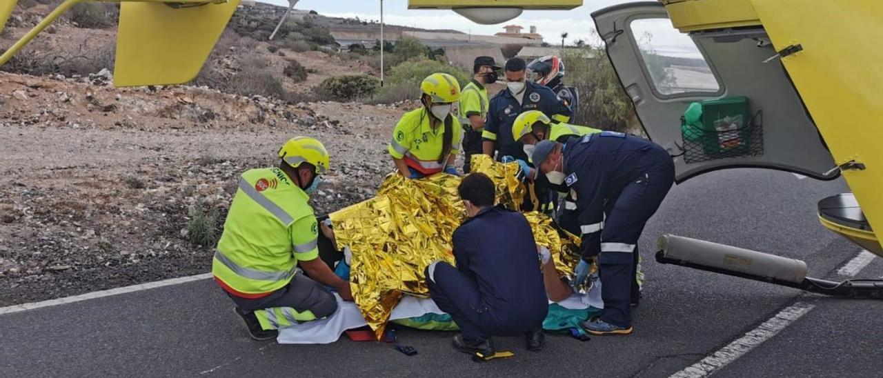 Personal del Servicio de Urgencias Canario (SUC) asiste a un accidentado junto al helicóptero del 112.