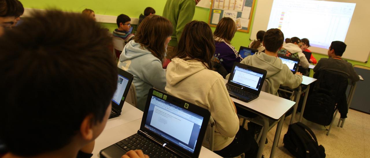 Imagen de archivo de un grupo de alumnos con portátiles en un aula catalana.