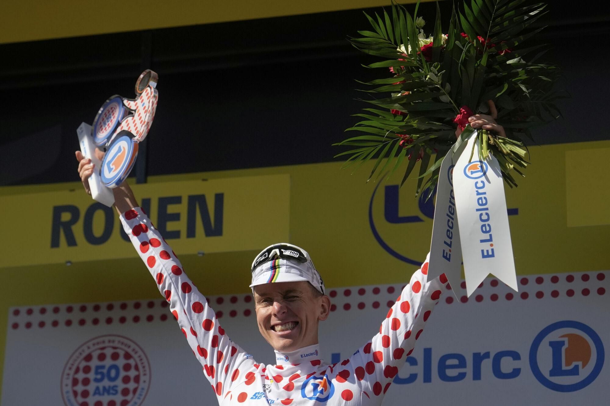 Slovenia's Tadej Pogacar wearing the best climber's dotted jersey celebrates on the podium after the fourth stage of the Tour de France cycling race over 172.2 kilometers (107 miles) with start in Amiens and finish in Rouen, France, Tuesday, July 8, 2025. (AP Photo/Mosa'ab Elshamy))