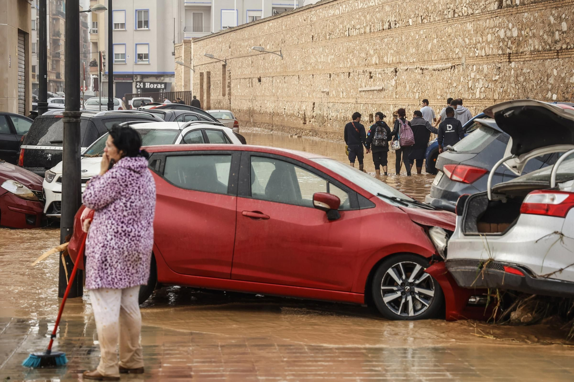 30/10/2024 Una mujer realiza labores de limpieza junto a vehículos destrozados tras el paso de la DANA por el barrio de La Torre de Valencia, a 30 de octubre de 2024, en Valencia, Comunidad Valenciana (España). La Comunitat Valenciana ha registrado la gota fría "más adversa" del siglo en la región. La Generalitat ha activado el procedimiento de múltiples víctimas por "prevención de lo que pueda venir", después de que el primer balance apunte a 51 víctimas mortales como consecuencia del temporal. En estos momentos, todavía hay personas esperando a ser rescatadas y puntos sin cobertura de telefonía y sin luz. ECONOMIA Rober Solsona - Europa Press