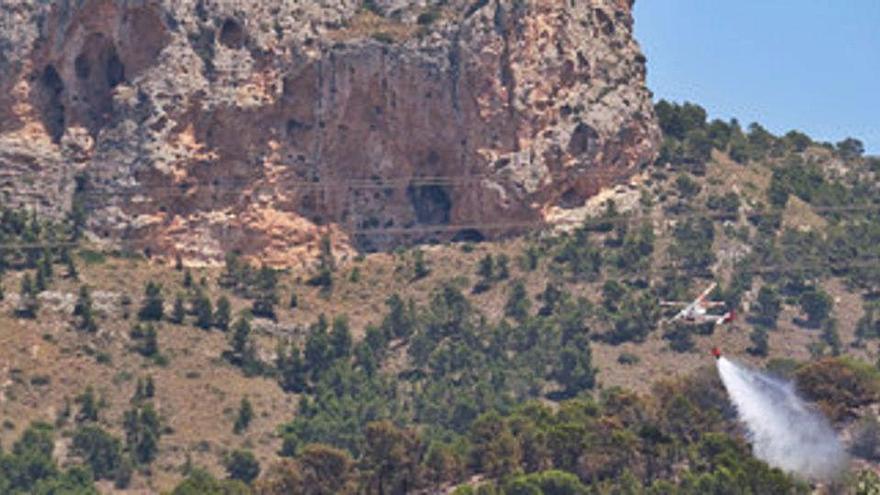 Los helicópteros regresaron a la pedanía de La Romaneta para refrigerar la zona y evitar que el fuego llegara a la sierra de la Zafra.