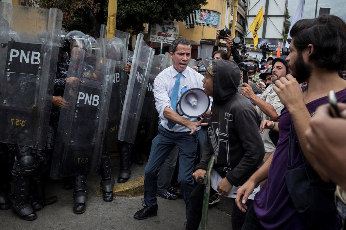 AME3191. CARACAS (VENEZUELA), 10/03/2020.- El líder opositor Juan Guaidó se une a simpatizantes durante los enfrentamientos con la Policía Nacional Bolivariana (PNB), este martes, en Caracas (Venezuela). La marcha había comenzado unos 30 minutos antes desde Chacao, un acomodado sector del este de Caracas y tradicional bastión opositor de la capital venezolana, y era la primera gran convocatoria de Guaidó desde que regresó de una gira internacional el pasado 11 de febrero. Al llegar a la zona, Guaidó cogió un megáfono y se metió entre los manifestantes y los policías, a quienes les dijo que en la marcha estaba la representación legítima del pueblo de Venezuela, en referencia a un nutrido grupo de diputados que intentaban llegar hasta el Palacio Legislativo para hacer la tradicional sesión de los martes. EFE/ Rayner Peña R.