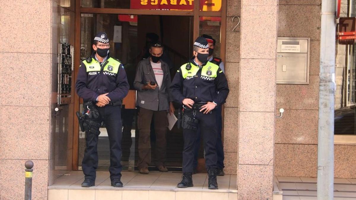 Dos agentes custodian el portal del edificio donde ha aparecido muerta una mujer.