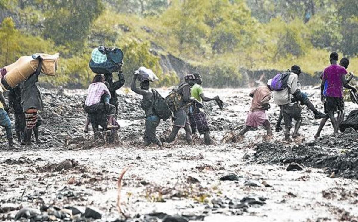 Ciutadans haitians intenten travessar el riu La Digue després que s’enfonsés el pont que el travessava.