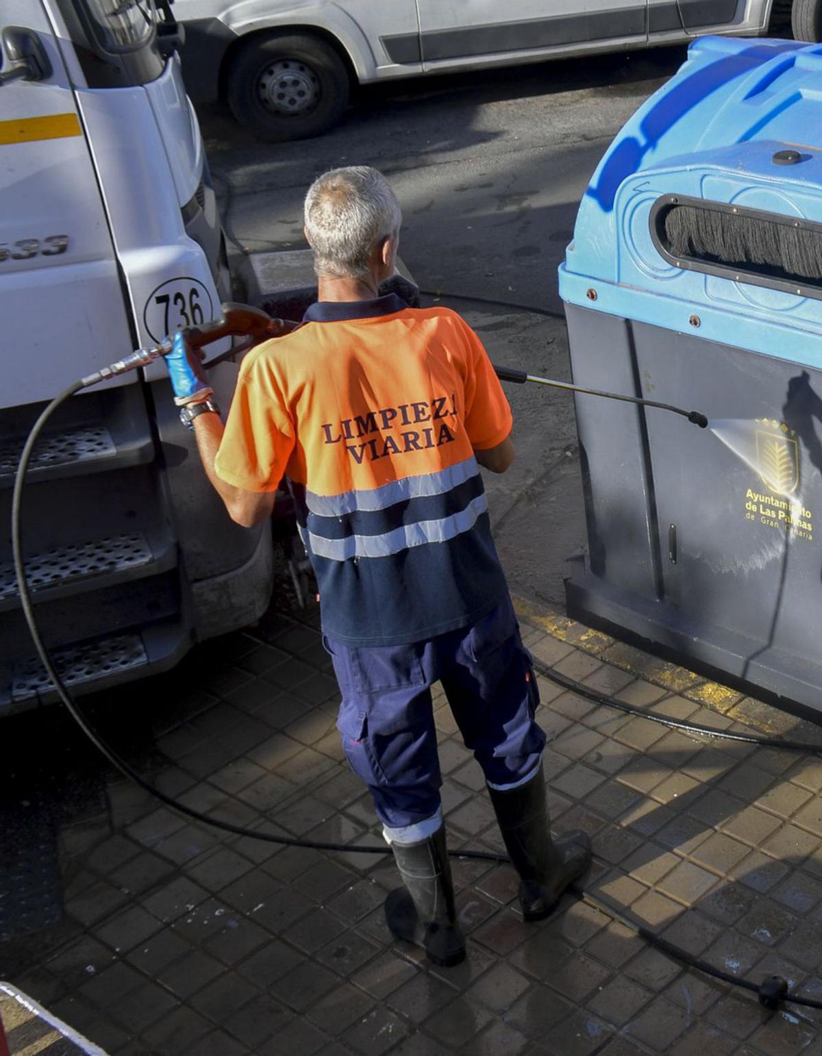 Un operario de Limpieza Viaria aplica agua a presión en un contenedor. | | JUAN CASTRO