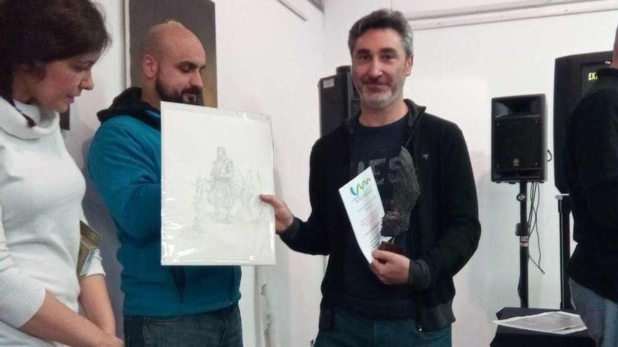 Luis Martín Espada, con el trofeo de mejor obra y una lámina, en la Casa de Cultura de Lugones.