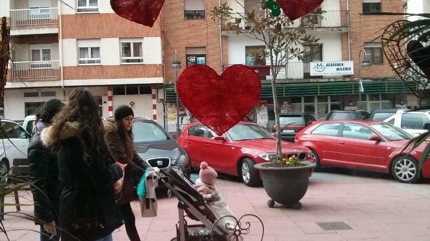 Varias mujeres pasan por delante de La Casa de las Flores, decorada con corazones.