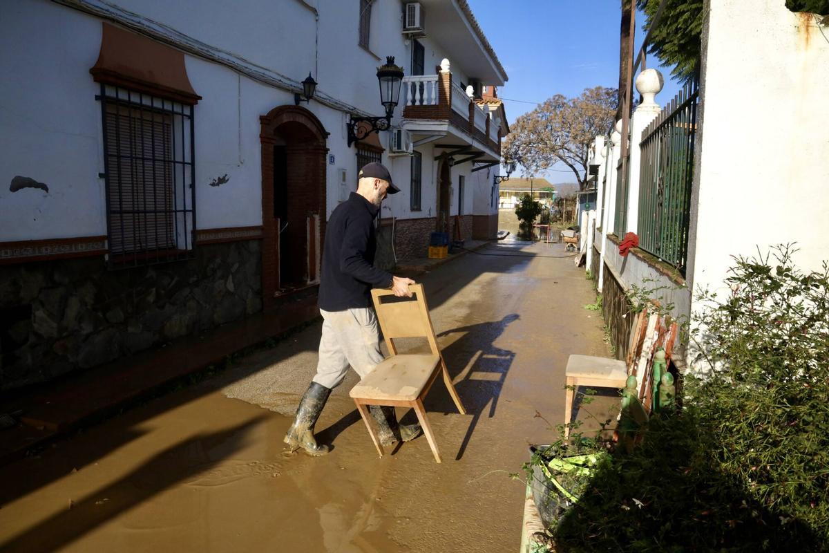 Los vecinos de la barriada de Doña Ana en la Estación de Cártama, junto al operarios Infoca, limpian los estragos de la nueva inundación provocada por la crecida del Guadalhorce durante la borrasca Francis