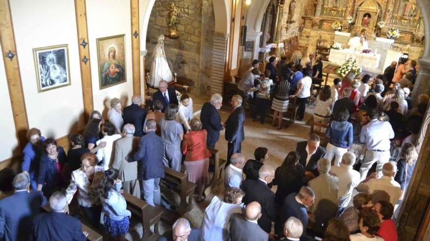 Las autoridades y los feligreses se dan la paz durante la celebración de la Santa Misa oficiada ayer en Robleda.