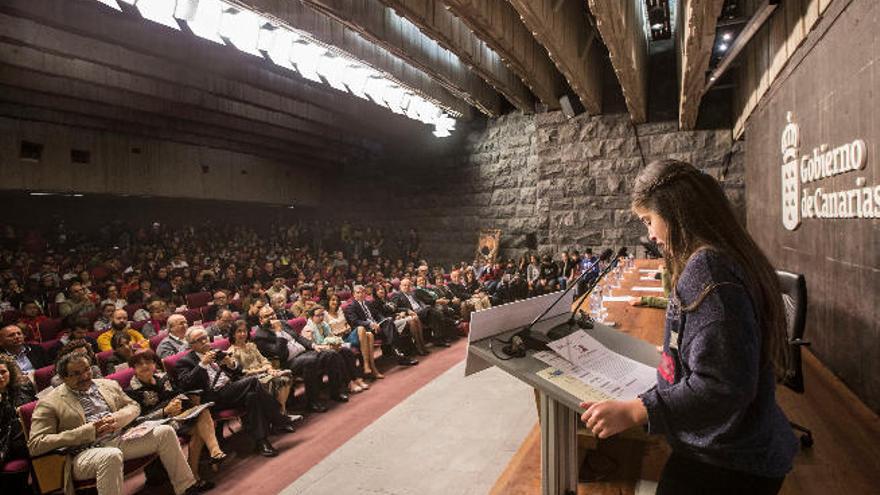 Una estudiante lee en el acto de homenaje a Rafael Arozarena, Día de Las Letras Canarias, en la sede de presidencia del Gobierno de Canarias, en Tenerife.