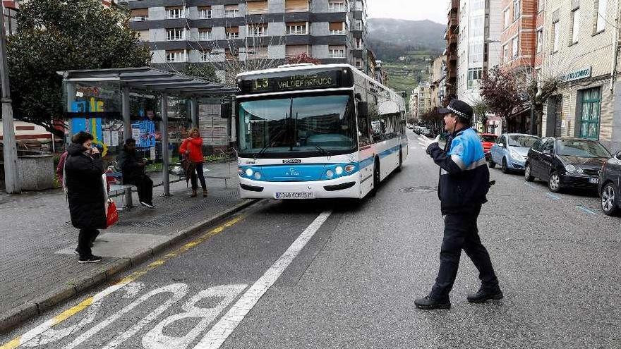 Usuarios del autobús urbano de Mieres reciben información de un agente de la Policía Local.