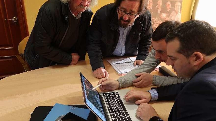 Ramón Cuervo y Luis Álvarez, de la Asociación de Vecinos de Cayés, observan cómo se desarrollará el estudio de aforo con el alcalde, Gerardo Sanz, y el responsable de la empresa Vectio, Carlos Suárez.