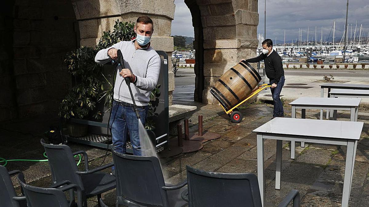 Desinfección de mesas y sillas para la reapertura en el Pazo de Mendoza, en Baiona. |   // RICARDO GROBAS