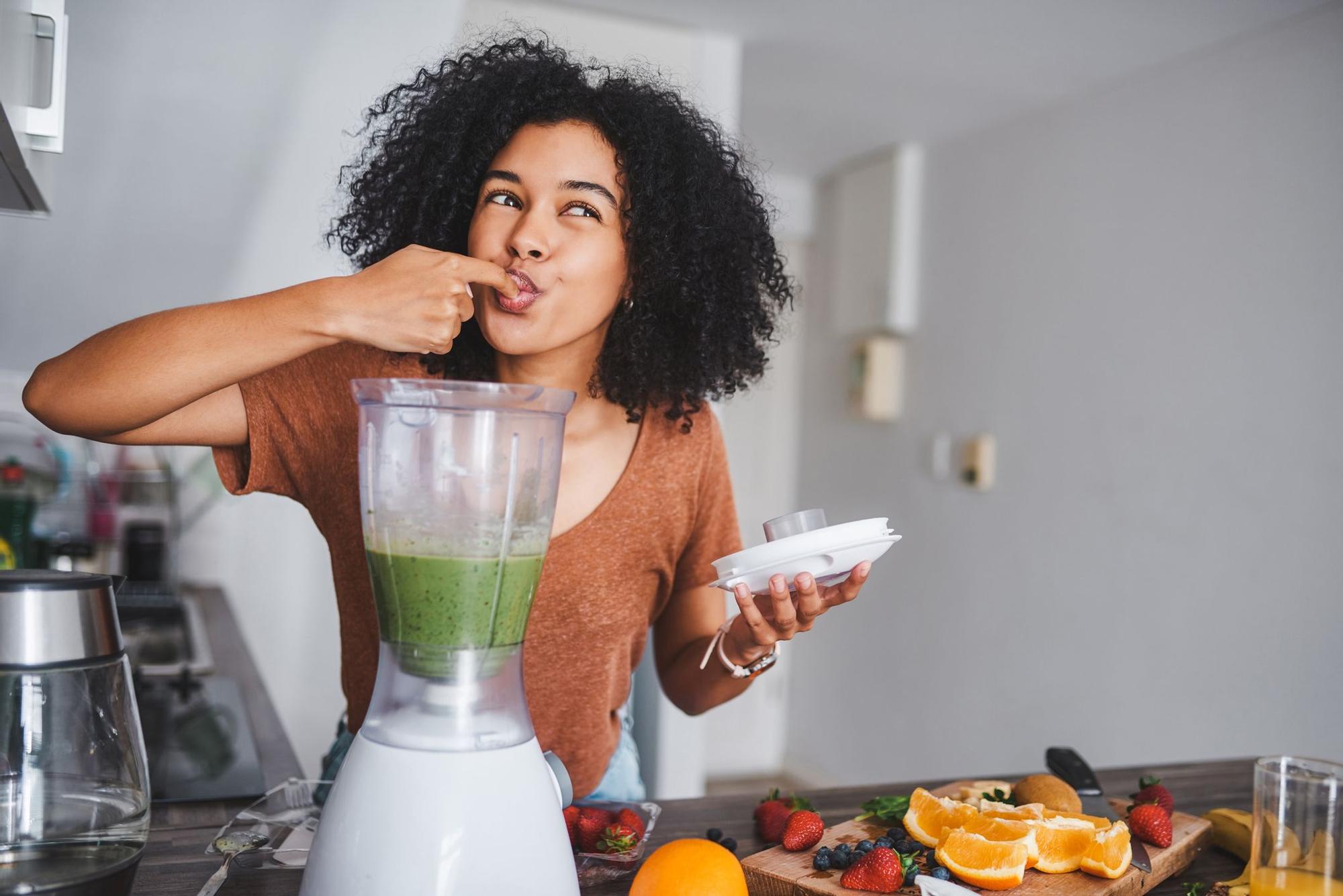 Una mujer haciendo un zumo de frutas