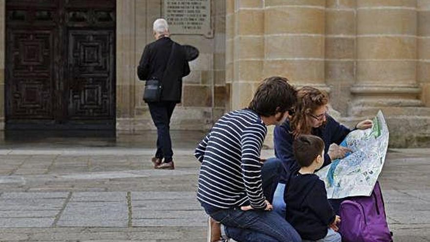 Unos turistas consultan el mapa de la ciudad en la plaza de la Catedral.