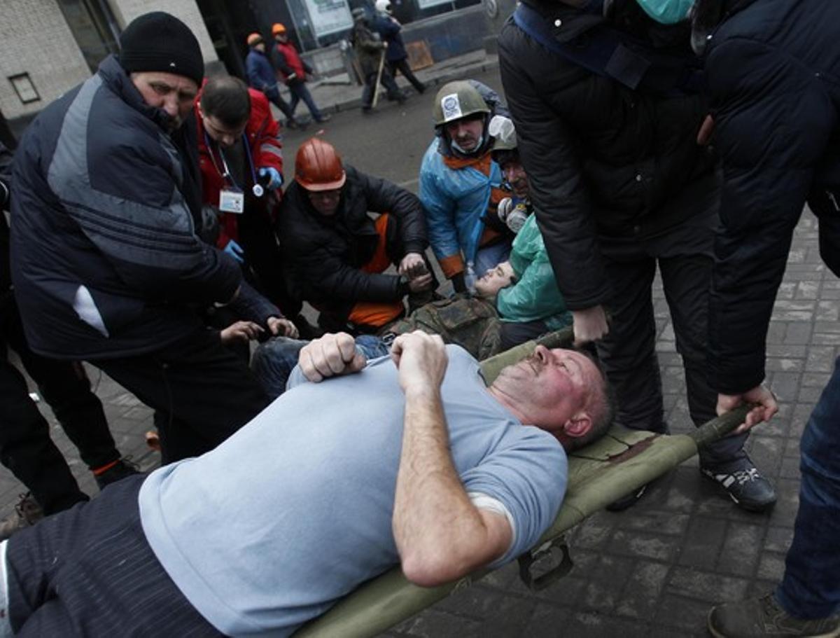 Un manifestante herido espera atención médica.