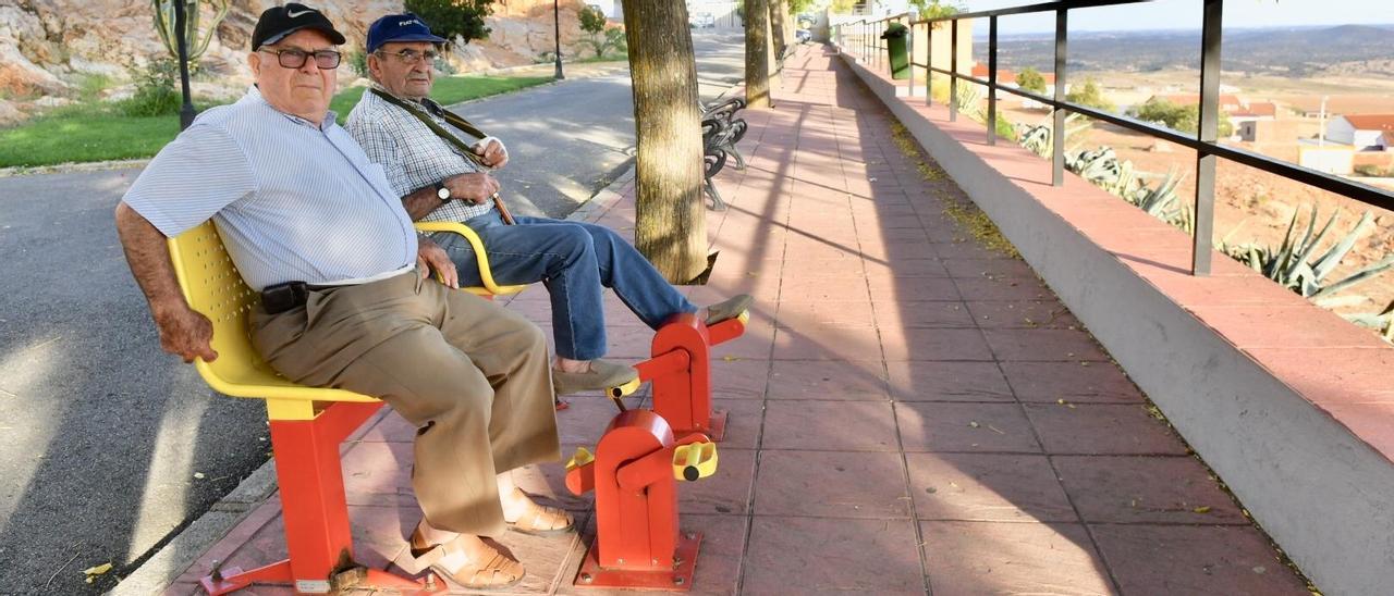 Dos hombres mayores hacen ejercicio en aparatos biosaludables en Santa Eufemia.
