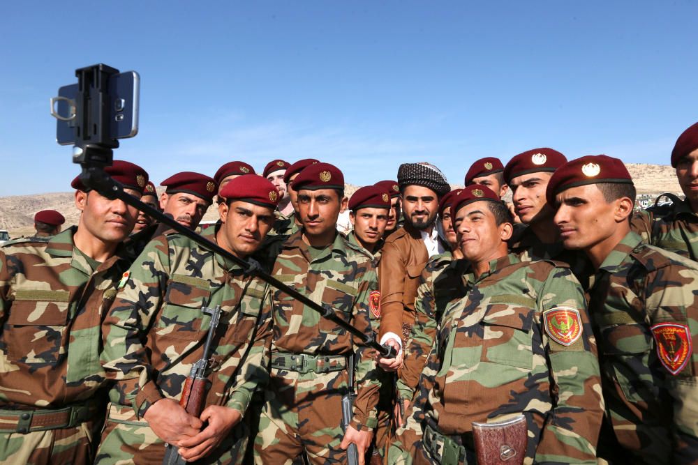 Un grupo de soldados árabes que se han unido a las fuerzas kurdas se hacen un selfi en la ceremonia de graduación en un campo de entranmiento en Iraq.