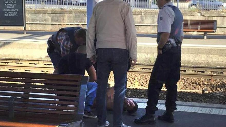 Agentes de la Policía registran en el suelo al autor del ataque dentro del tren.