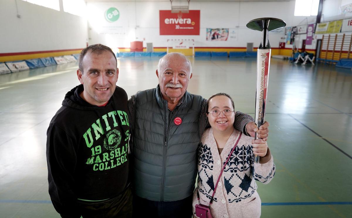 José Antonio Quintero, que sujeta en la mano una antorcha olímpica de Barcelona'92, posa en el polideportivo de Envera junto a Dani, futbolista, y Macarena, deportista de gimnasia artística y expresión corporal.