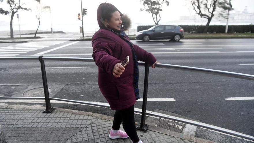 Una mujer camina con dificultad en A Coruña un día ventoso.