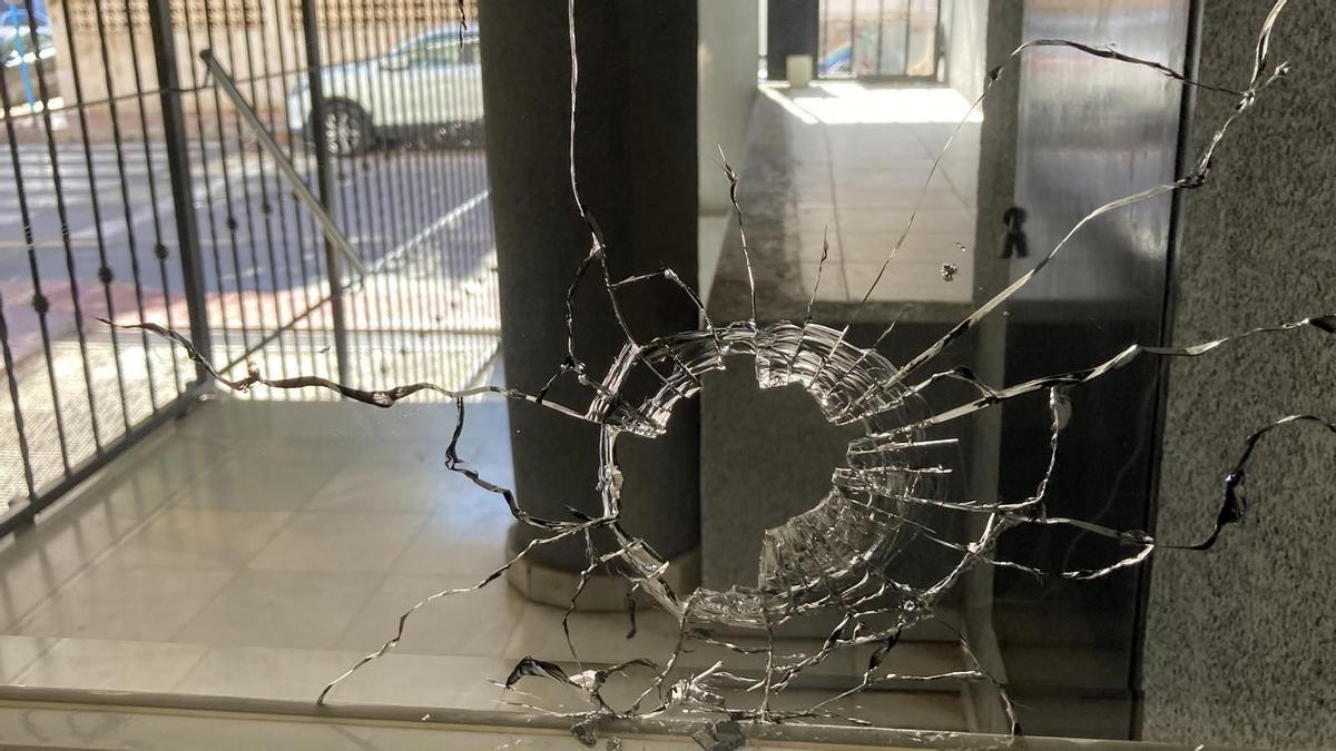 Impacto de bala en una de las ventanas del rellano del edificio donde se produjo el tiroteo en Torrevieja.