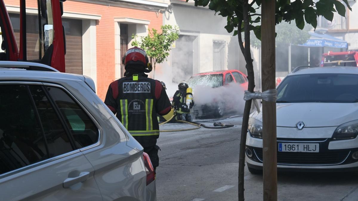 Los bomberos sofocan el fuego del vehículo siniestrado en Baena.