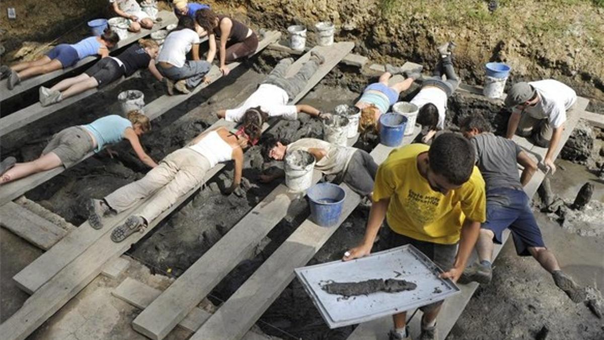 Un grupo de arqueólogos trabaja en las excavaciones del Parque Neolótico de la Draga, en Banyoles, donde se ha hallado el arco de caza neolítico más antiguo de Europa.