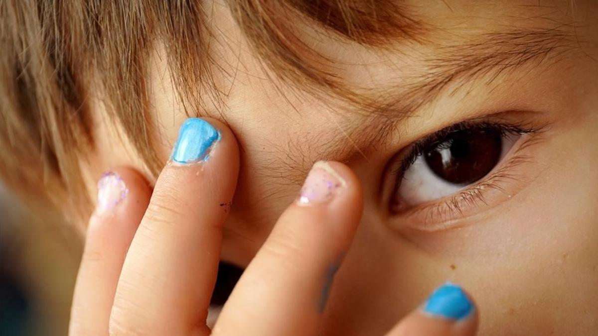 Un niño de cuatro años muestra sus uñas pintadas.