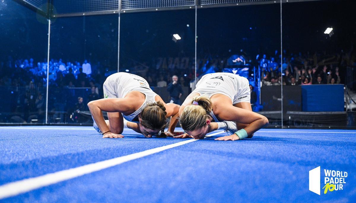 Paula Josemaría y Ariana Sánchez besan el césped de la pista de Ámsterdam tras ganar el torneo.
