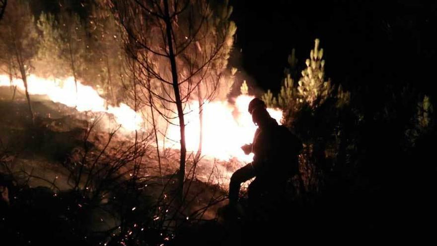 Un efectivo intenta sofocar el fuego de Ibias.