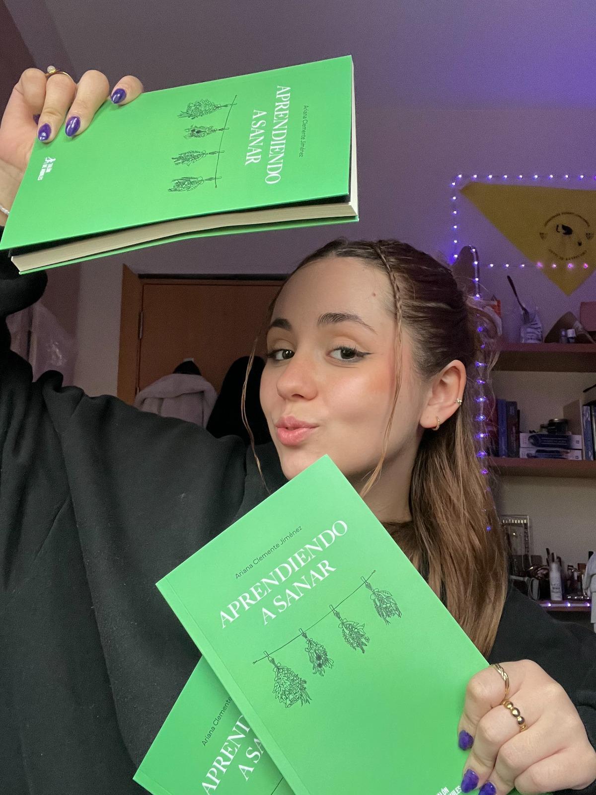 Ariana Clemente, de Plasencia, rodeada de ejemplares de su primero poemario para transitar la adolescencia.