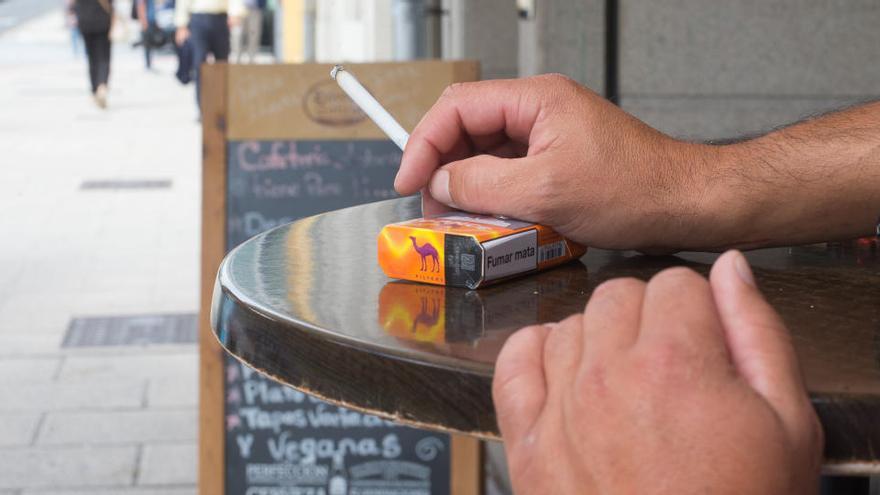 Una persona fumant en una terrassa de bar