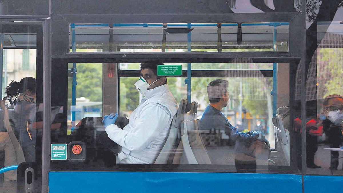 Varias personas con mascarilla en el interior de un autobús, en Palma.