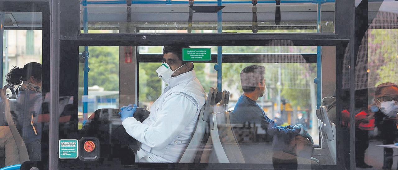 Varias personas con mascarilla en el interior de un autobús.