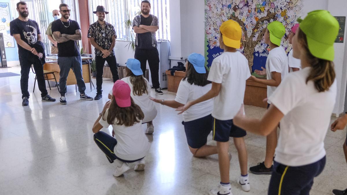 Los alumnos ganadores del concurso del CEIP Pepe Dámaso bailando el estribillo de la canción frente a la banda.