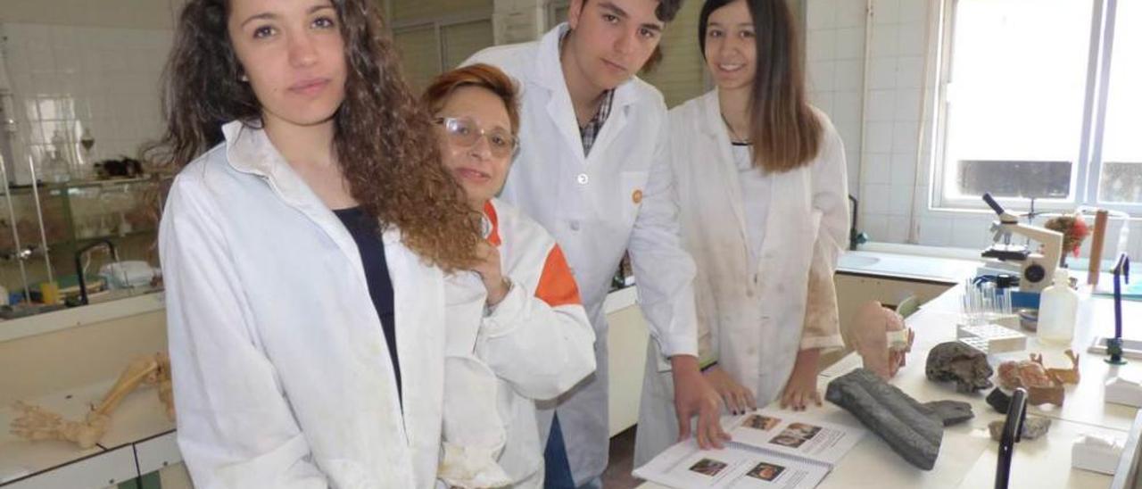 Por la izquierda, Julia Bermúdez, María del Rosario Ruiz, Pablo Cachón y Susana Leiguarda, en el laboratorio del centro, con su libro en la mesa.