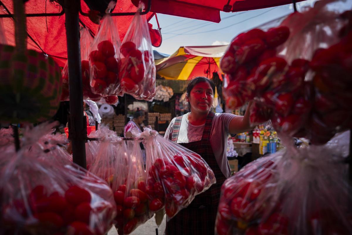 Una mujer atiende a la gente en un mercado callejero de San Salvador.