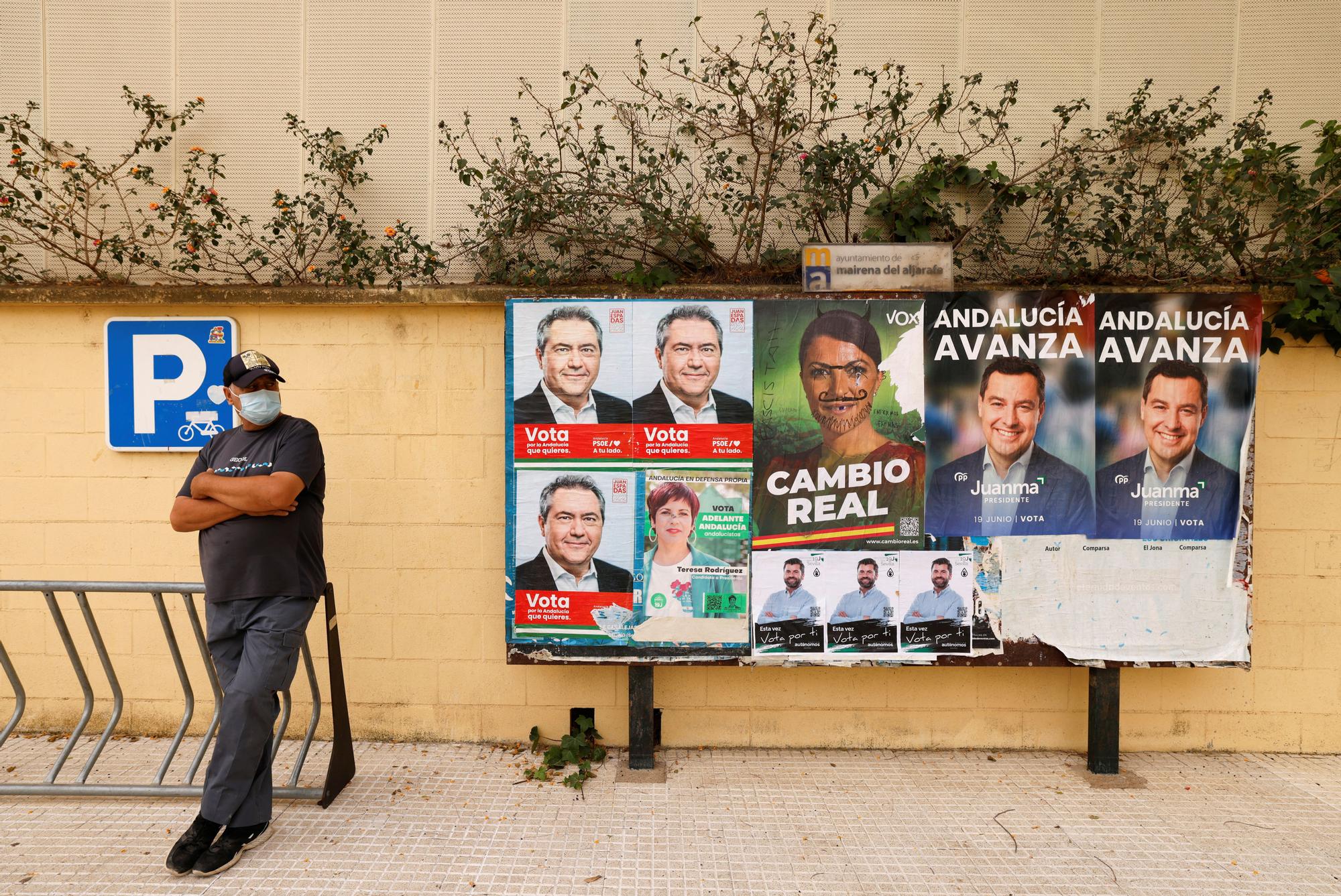 Un hombre frente a unos carteles electorales de las elecciones en Andalucía, en Mairena de Aljarafe, Sevilla.