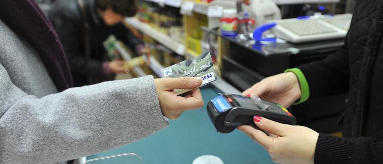 Una persona pagando con tarjeta  social que el Ayuntamiento puso en pruebas en un supermercado de Elche, en 2019. | MATÍAS SEGARRA