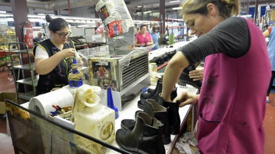 Trabajadoras de una empresa de calzado de la provincia repasando botines de invierno.
