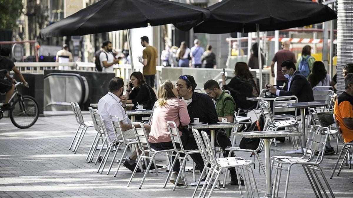 Varios clientes disfrutan del primer día de terrazas abiertas de Barcelona, en el Café Zúrich, este lunes 25 de mayo