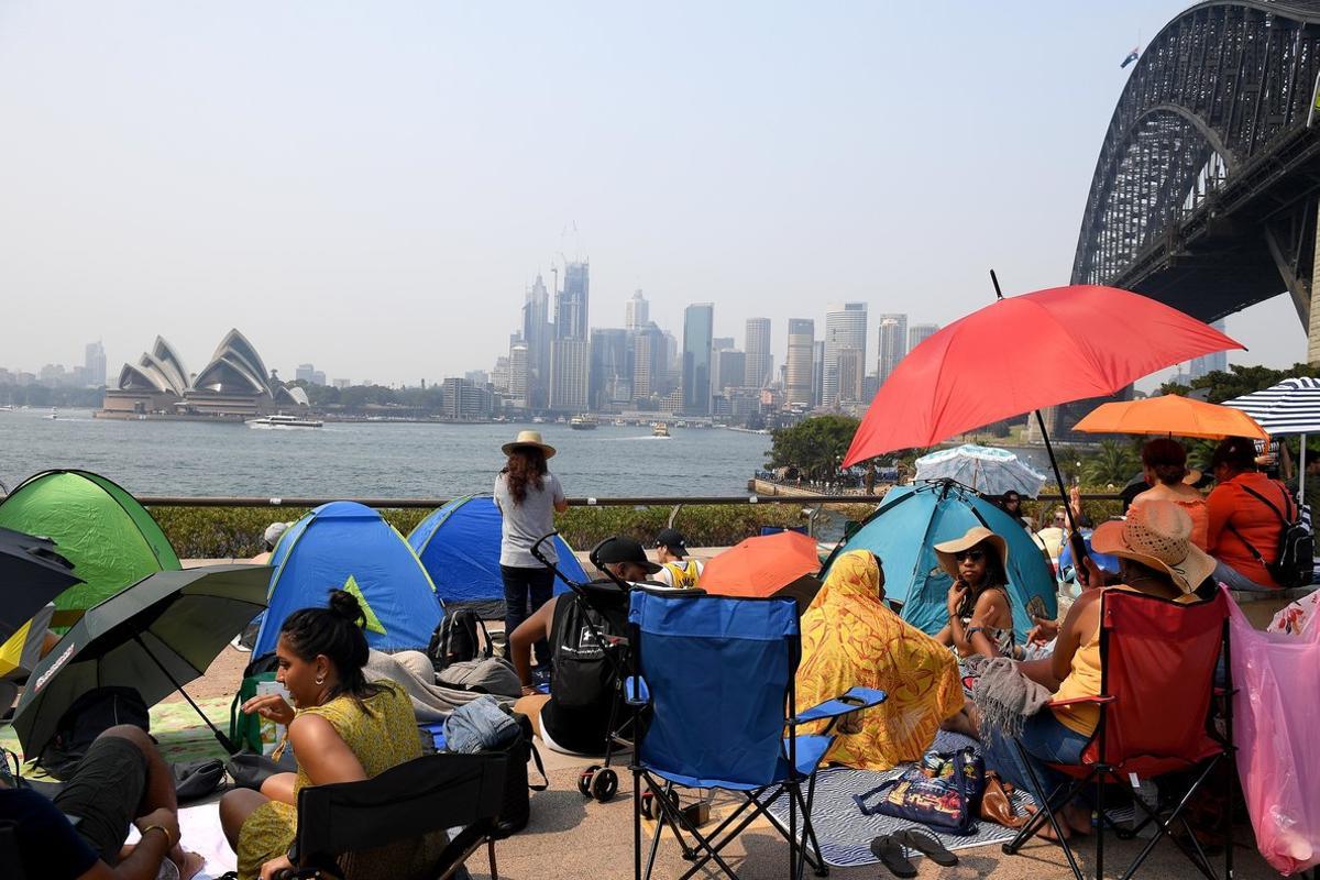 Sydney (Australia), 31/12/2019.- People claim early harbourside positions at Kirribilli ahead of the New Year’s Eve fireworks display in Sydney, Australia, 31 December 2019. (Incendio) EFE/EPA/MICK TSIKAS AUSTRALIA AND NEW ZEALAND OUT