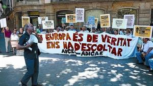 Concentración de afectados por preferentes y cláusulas suelo convocada por Adicae ante la sede de la UE en Barcelona.