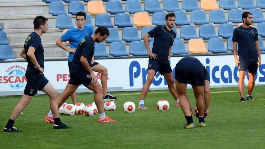 La plantilla del Pontevedra realiza ejercicios de estiramiento al término de una sesión de trabajo en el estadio municipal de Pasarón. // Rafa Vázquez