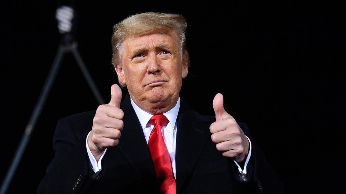 US President Donald Trump gives two thumbs up during a rally in support of Republican incumbent senators Kelly Loeffler and David Perdue ahead of Senate runoff in Dalton  Georgia on January 4  2021  - President Donald Trump  still seeking ways to reverse his election defeat  and President-elect Joe Biden converge on Georgia on Monday for dueling rallies on the eve of runoff votes that will decide control of the US Senate  Trump  a day after the release of a bombshell recording in which he pressures Georgia officials to overturn his November 3 election loss in the southern state  is to hold a rally in the northwest city of Dalton in support of Republican incumbent senators Kelly Loeffler and David Perdue  (Photo by MANDEL NGAN   AFP)
