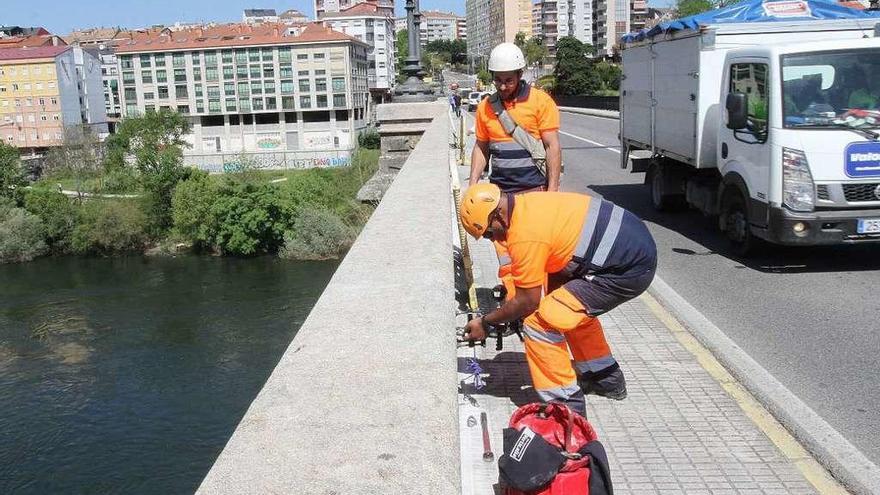 Operarios instalando los anclajes en el muro del puente para hacer la limpieza en altura. // Iñaki Osorio