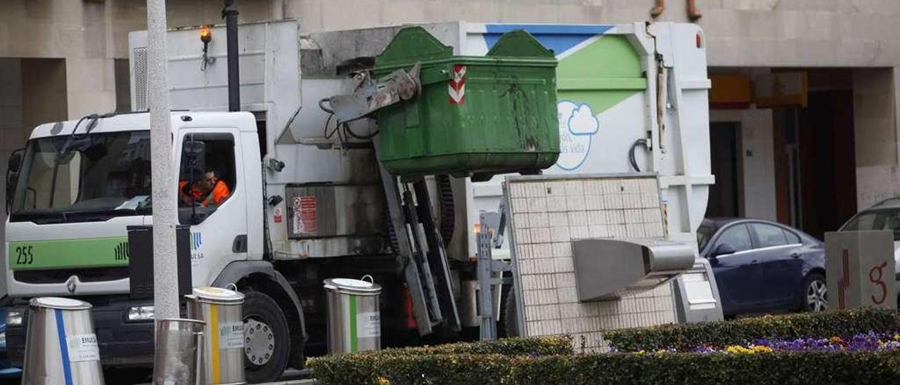 Un camión recoge basura en la zona de Moreda.