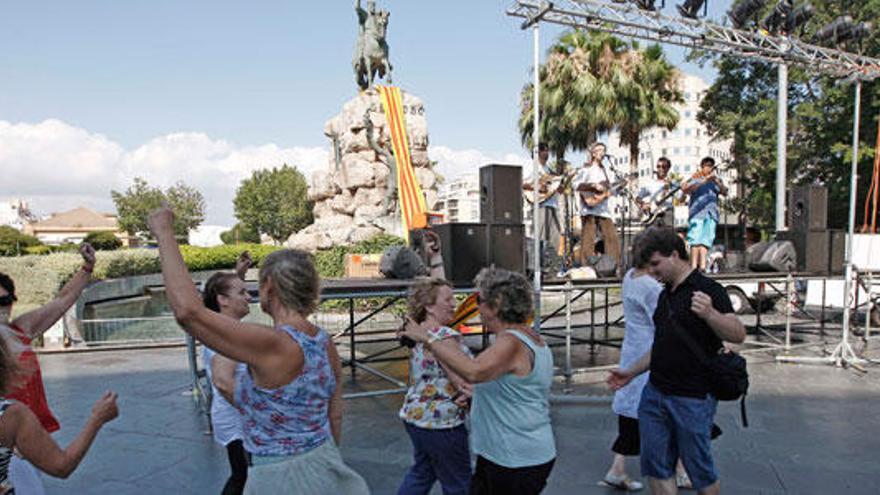Un grupo de persoans baila en la plaza de España en defensa del catalán.